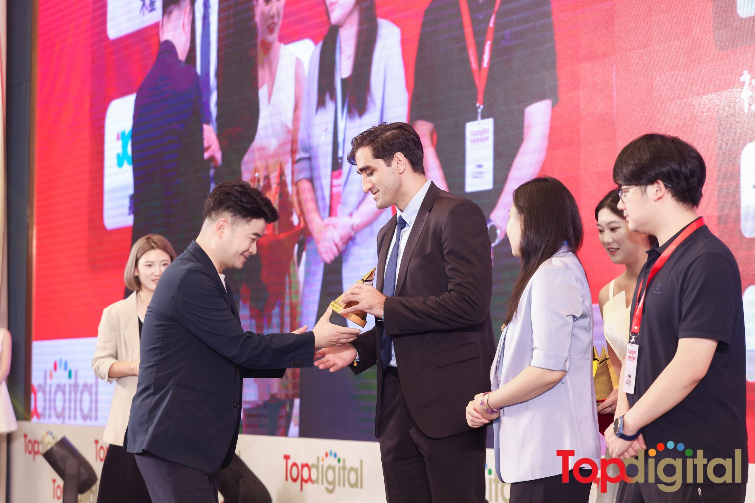 Omid Pourmomen accepting TopDigital Award on stage